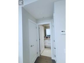 Vancouver apartment for rent - A white hallway with a doorway leading to a kitchen.