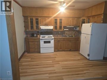 Hamilton apartment for rent - A kitchen with wooden cabinets and a white fridge.
