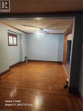 Hamilton apartment for rent - A room with wooden floors and a ceiling fan.