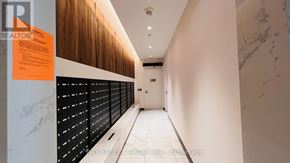 Toronto (Clanton Park) condo for rent - A hallway with a marble floor and a wooden panel on the wall.