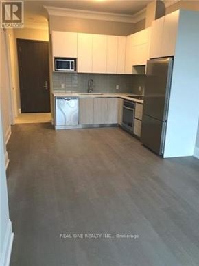 Markham (Unionville) condo for rent - A kitchen with white cabinets and a black door.