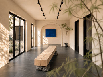 Santa Fe apartment for rent - A long wooden bench sits in the middle of a room with a large screen on the wall.