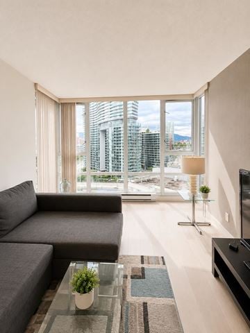 Vancouver apartment for rent - A modern living room with a grey sofa and a glass coffee table.