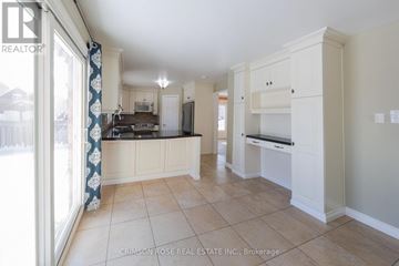 Oakville (Ga Glen Abbey) apartment for rent - A spacious kitchen with white cabinets and a tiled floor.