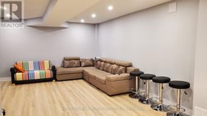 Markham (Cedar Grove) apartment for rent - A living room with a couch, ottoman, and bar stools.