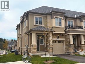 Ancaster townhouse for rent - A large, two-story house with a garage and a balcony on the second floor.