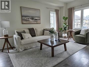 Ancaster townhouse for rent - A living room with a white couch, a coffee table, and a painting on the wall.