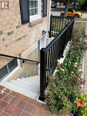 Niagara-On-The-Lake (Town) apartment for rent - A yellow car is parked on the street behind a house with a black railing.