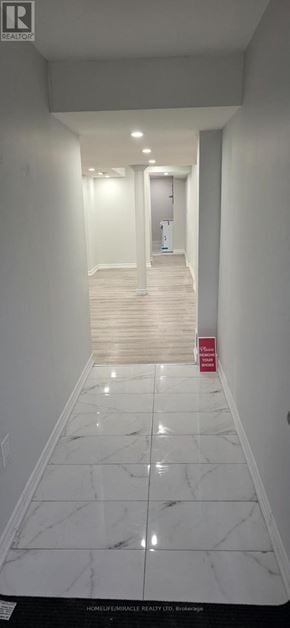Toronto (Rouge) townhouse for rent - A long hallway with white walls and marble floors.