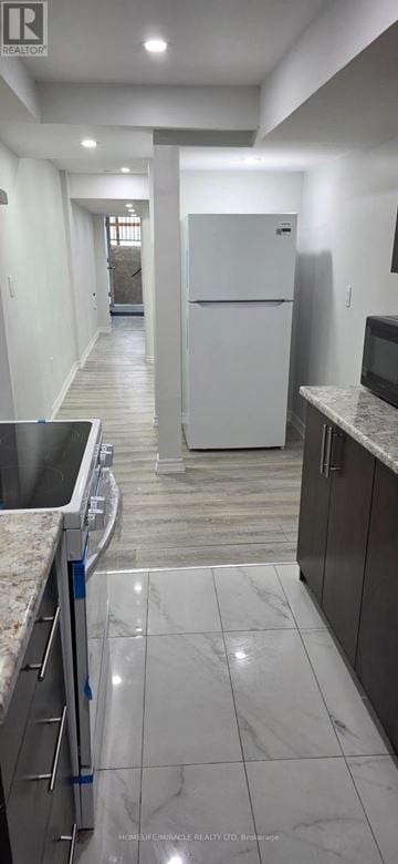 Toronto (Rouge) townhouse for rent - A kitchen with a white fridge and a marble floor.