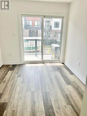 Kitchener townhouse for rent - A room with a sliding door leading to a balcony.