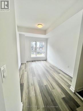 Kitchener townhouse for rent - A room with wood flooring and a window overlooking a balcony.