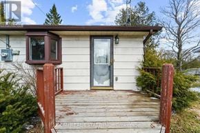 Trent Hills apartment for rent - A small house with a wooden deck and a glass door.