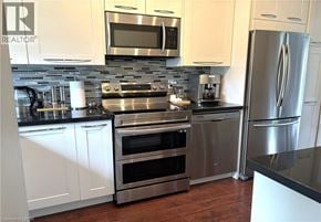 Hamilton apartment for rent - A modern kitchen with stainless steel appliances and white cabinets.