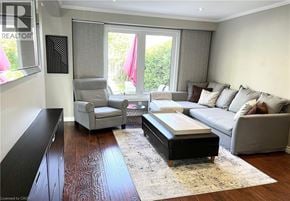 Hamilton apartment for rent - A living room with a grey couch, a grey armchair, a coffee table, and a rug.