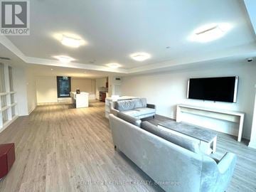 Toronto (Kensington-Chinatown) condo for rent - A spacious living room with a grey sofa and a flat screen TV.