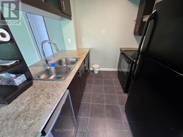 Toronto (Bendale) condo for rent - A kitchen with a black refrigerator and a granite countertop.