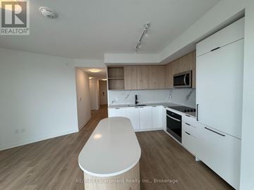 Toronto (Dovercourt-Wallace Emerson-Junction) condo for rent - A white kitchen with wooden cabinets and a white island.