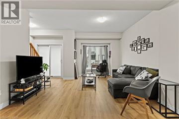 Stoney Creek townhouse for rent - A living room with a black sofa and a television.