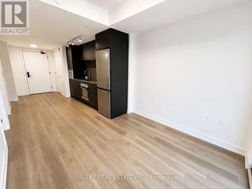 Hamilton (Beasley) condo for rent - A kitchen area with a black refrigerator and wooden flooring.