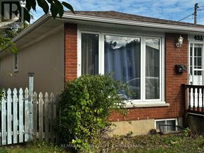 St. Catharines (Port Weller) apartment for rent - A house with a white picket fence in front of it.