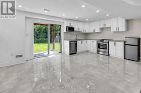 Clarington (Bowmanville) apartment for rent - A modern kitchen with white cabinets and a marble floor.