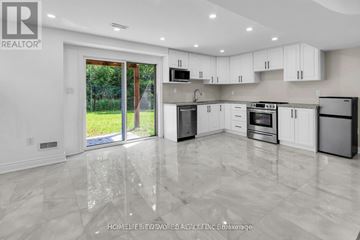 Clarington (Bowmanville) apartment for rent - A modern kitchen with white cabinets and a marble floor.