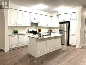 Brampton (Bram West) townhouse for rent - A kitchen with white cabinets and a central island.