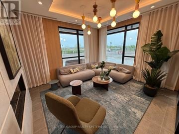 Milton (Cb Cobban) condo for rent - A living room with a large window, a sofa set, a coffee table, and a potted plant.