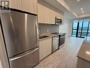 Milton (Cb Cobban) condo for rent - A modern kitchen with stainless steel appliances and wooden cabinets.