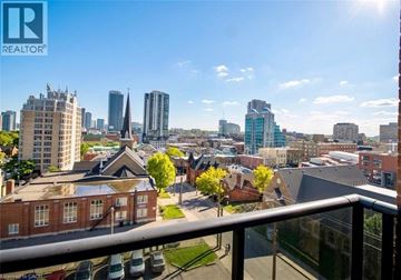 Kitchener condo for rent - A cityscape with a mix of modern and older buildings, viewed from a balcony.