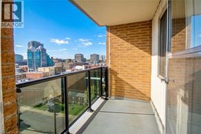 Kitchener condo for rent - A balcony with a glass railing overlooking a cityscape.
