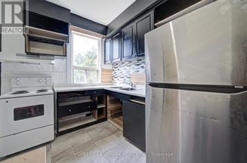 Toronto (Dovercourt-Wallace Emerson-Junction) apartment for rent - A modern kitchen with a white stove and black cabinets.