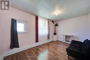 Toronto (Dovercourt-Wallace Emerson-Junction) apartment for rent - A living room with a black couch and wooden floors.
