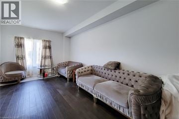 Brantford townhouse for rent - A living room with a brown sofa and a chair.