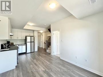 Toronto (Eglinton East) townhouse for rent - A spacious kitchen with white cabinets and a stainless steel refrigerator.