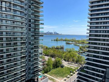Toronto (Mimico) condo for rent - A view from a high-rise building looking out over a body of water with a distant industrial area.
