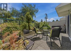 Vancouver apartment for rent - A patio with chairs and a table surrounded by greenery.