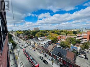 Toronto (South Parkdale) condo for rent - A city street with a red bus and cars on a cloudy day.
