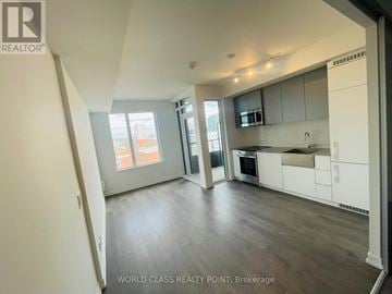 Toronto (South Parkdale) condo for rent - A spacious kitchen with white cabinets and a large island.