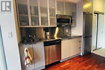 Toronto (Bay Street Corridor) condo for rent - A kitchen with a stainless steel refrigerator and microwave.