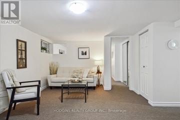 Mississauga (Mineola) duplex for rent - A living room with a white couch and a wooden chair.