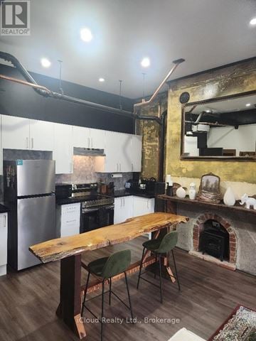Hamilton (Dundas) multi-family for rent - A kitchen with a wooden table and chairs.