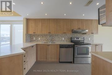 Ottawa townhouse for rent - A kitchen with wooden cabinets and a tiled backsplash.