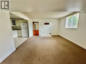 Cambridge apartment for rent - A room with a brown carpet and a door leading to a kitchen.