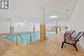 St. Catharines (Glendale/Glenridge) condo for rent - A large indoor swimming pool with a chair on the side.