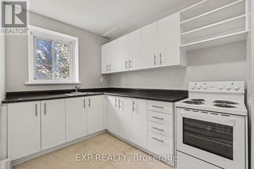 Ottawa multi-family for rent - A white kitchen with a stove and cabinets.