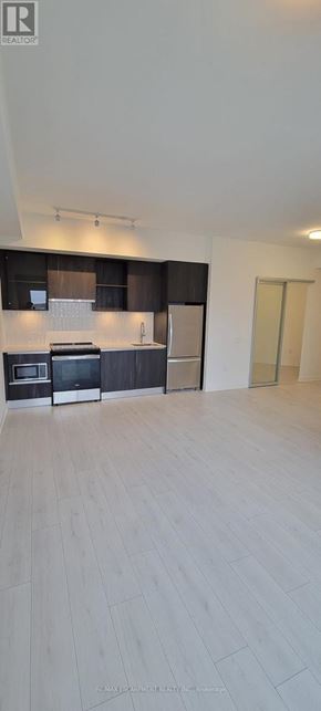 Oakville (Go Glenorchy) condo for rent - A spacious kitchen with wooden flooring and modern appliances.