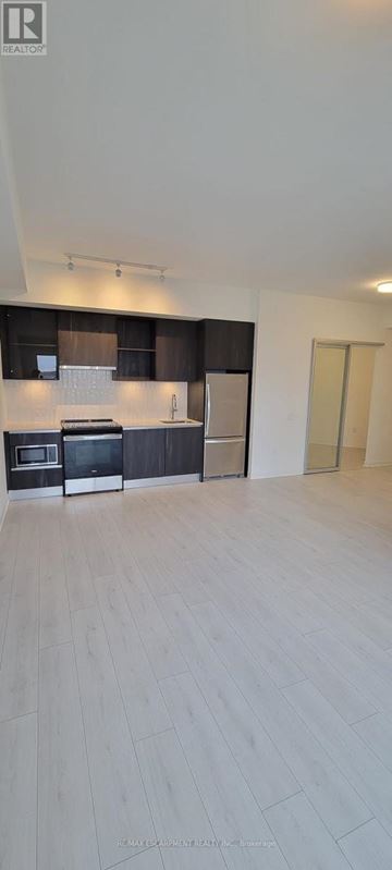 Oakville (Go Glenorchy) condo for rent - A spacious kitchen with wooden flooring and modern appliances.