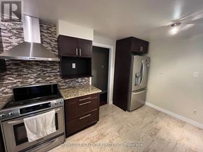 London North (North F) apartment for rent - A kitchen with a stove top oven and a refrigerator.